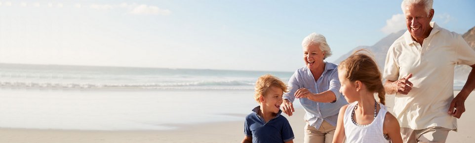 Seniors with grandchildren on beach